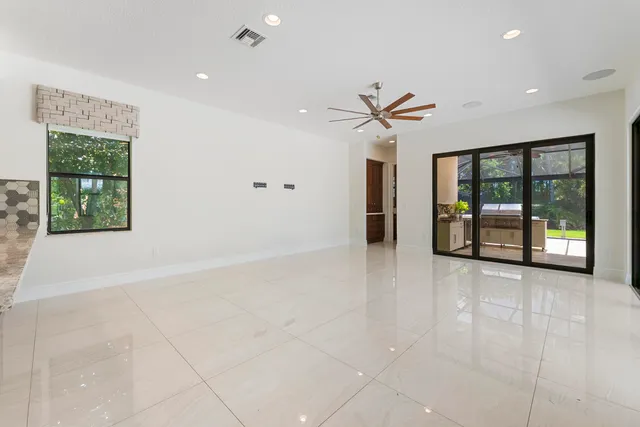a large kitchen with kitchen island a large counter top stainless steel appliances and cabinets