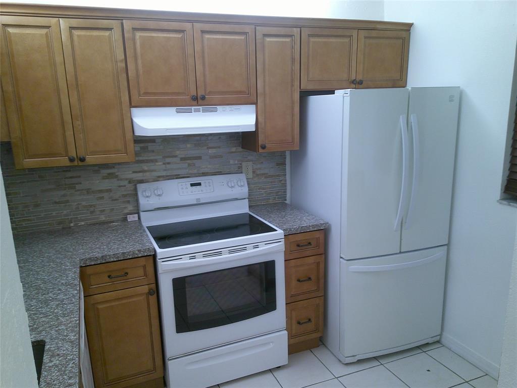 3199 Foxcroft Road, Unit 306 Miramar, FL 33025 - Photo 4 of 12 a kitchen with granite countertop cabinets and refrigerator