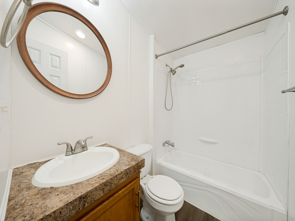 4654 Old Howard Road Temple, TX 76504 - Photo 20 of 25 A well-appointed bathroom featuring a white sink vanity with a warm wood cabinet, framed mirror, and clean bathtub.