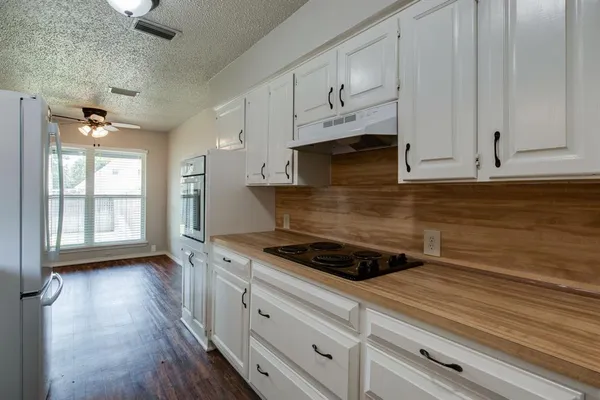 a kitchen with stainless steel appliances granite countertop a stove a sink and white cabinets
