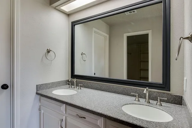 a bathroom with a granite countertop sink and a mirror