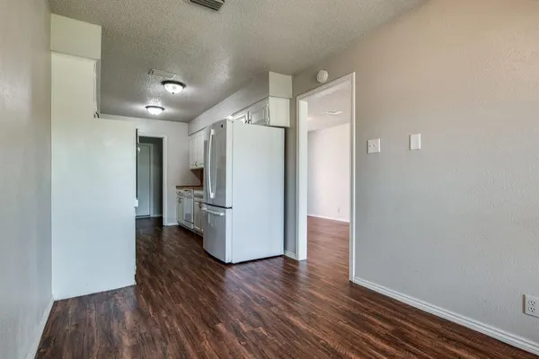 a view of a kitchen with wooden floor and a refrigerator