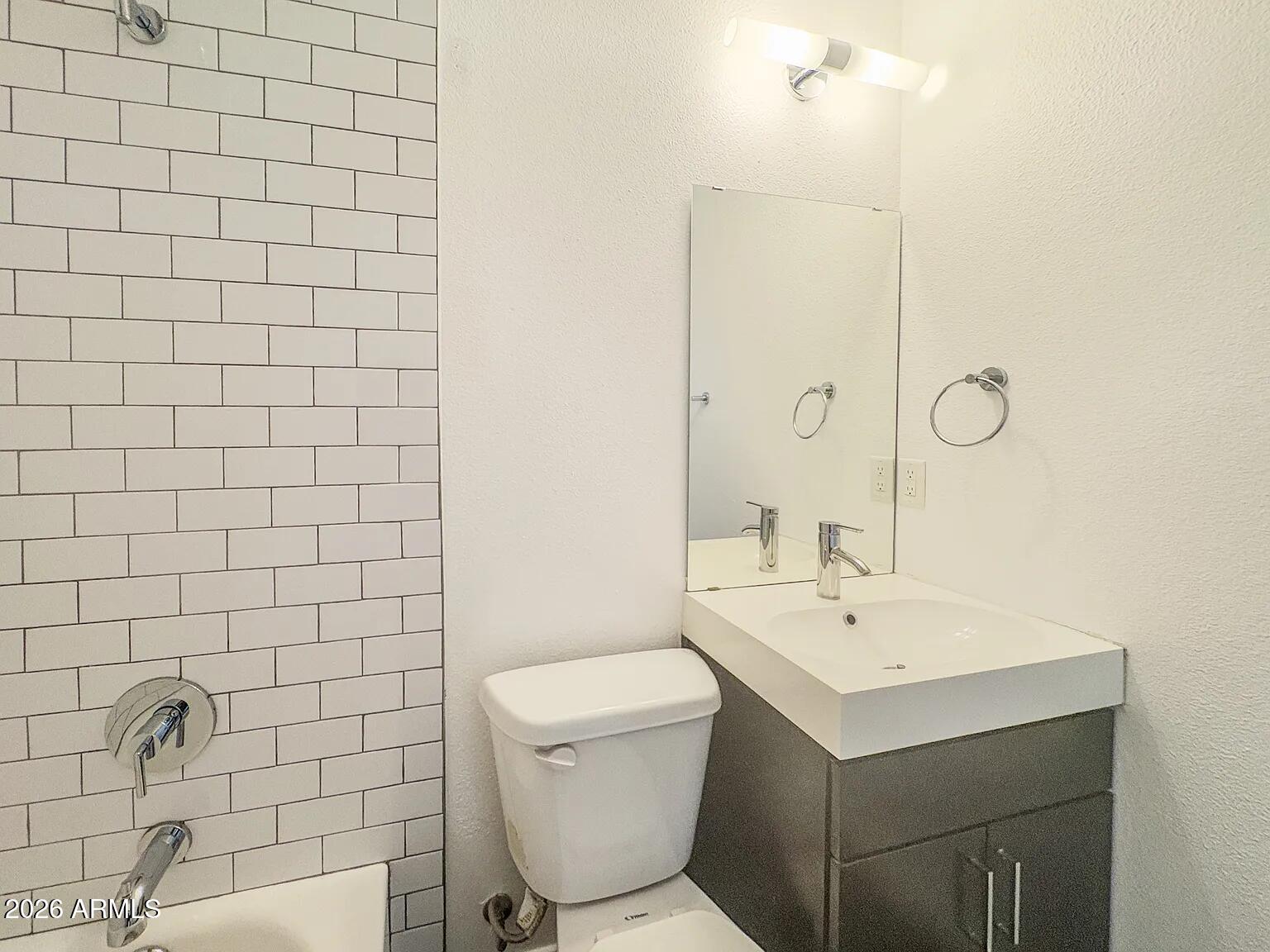 4231 North 27th Street, Unit 10 Phoenix, AZ 85016 - Photo 6 of 14 a bathroom with a sink mirror and toilet