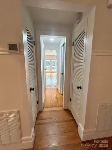 a view of a hallway with wooden floor and staircase