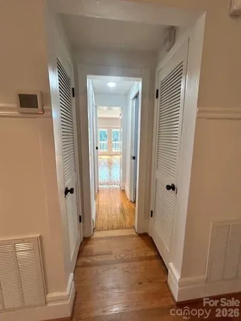 a view of a hallway with wooden floor and staircase