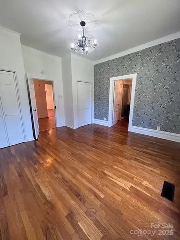 a view of a livingroom with wooden floor and workspace