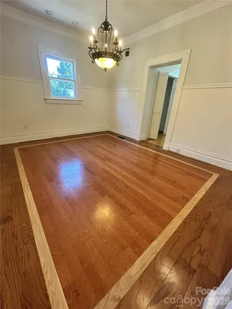 a view of a room with wooden floor and chandelier