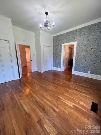 a view of a livingroom with wooden floor and workspace