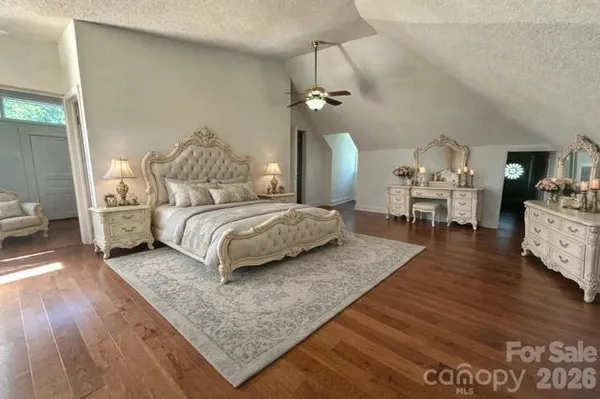 a bedroom with a bed chandelier and a couch