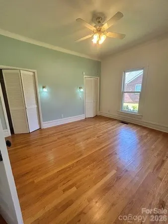 a view of a room with wooden floor and a ceiling fan
