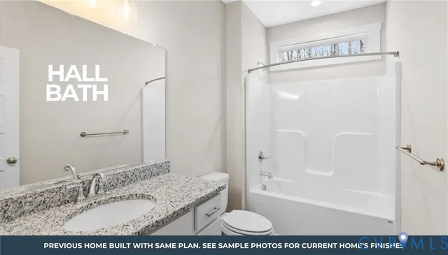 a bathroom with a granite countertop sink a mirror and a bathtub