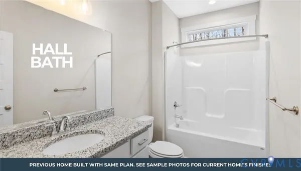 a bathroom with a granite countertop sink a mirror and a bathtub