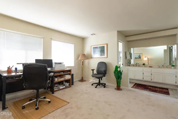 a view of a workspace with furniture and a window