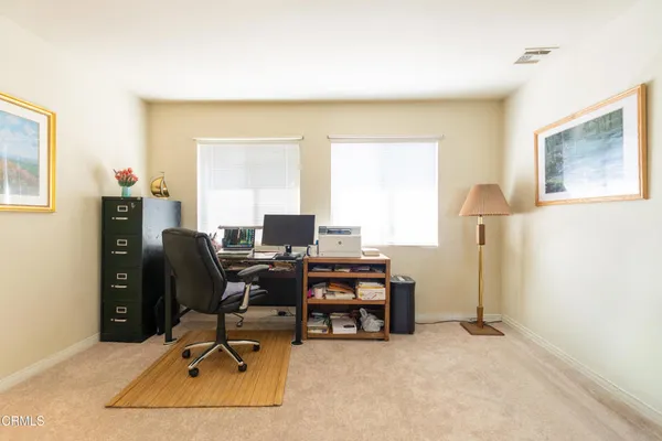 a view of a workspace with furniture and a window
