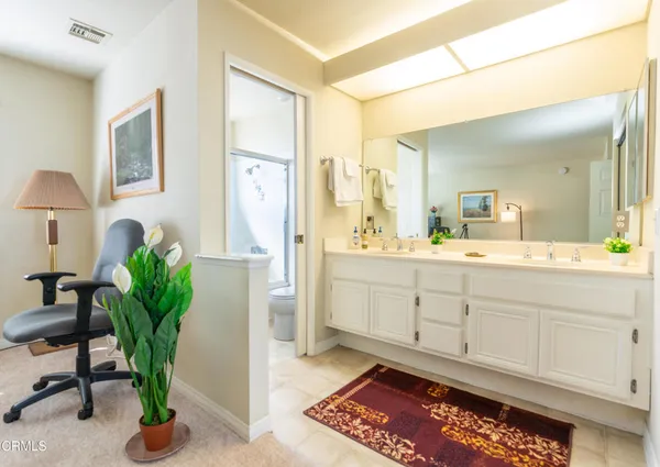 a spacious bathroom with stainless steel appliances a sink and a mirror