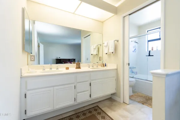 a bathroom with a double vanity sink mirror and toilet