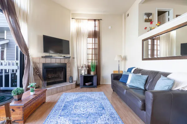a living room with furniture a flat screen tv and a fireplace