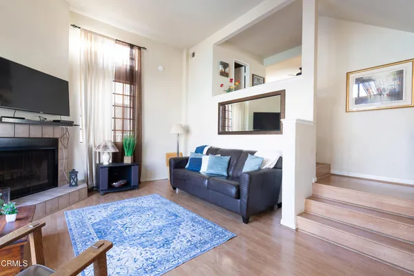 a living room with furniture a flat screen tv and a fireplace