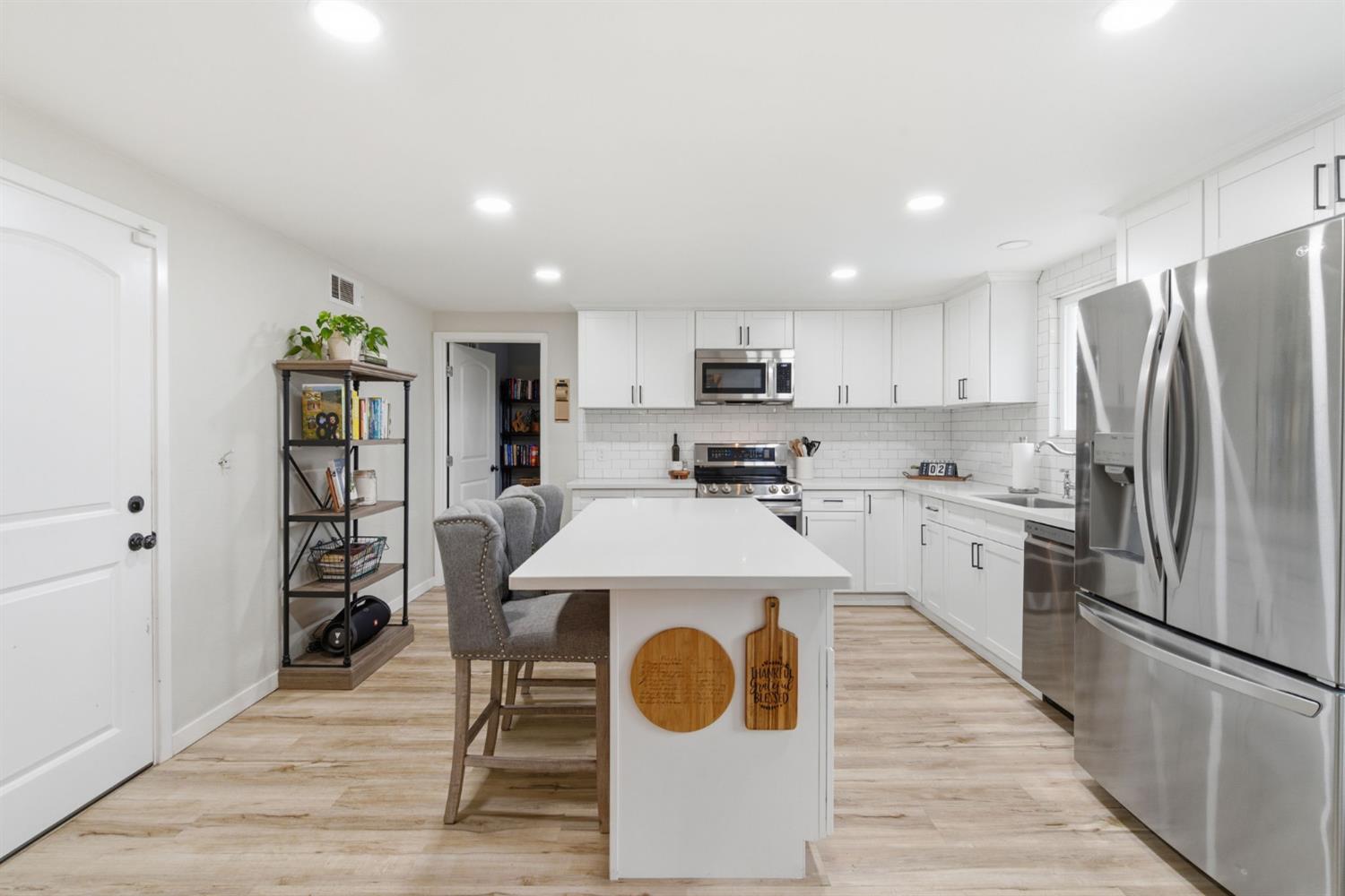 15581 French Camp Road Ripon, CA 95366 - Photo 15 of 54 a kitchen with kitchen island wooden cabinets and refrigerator