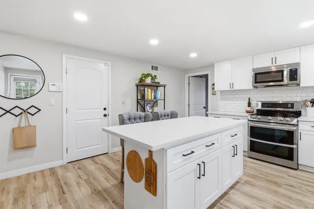 a kitchen with cabinets and wooden floor