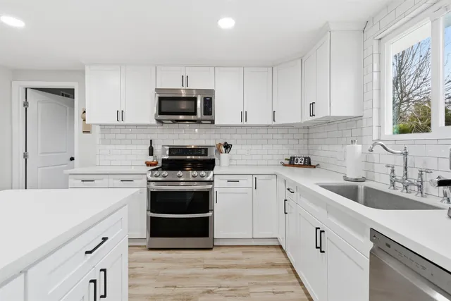 a kitchen with cabinets appliances a sink and a counter space