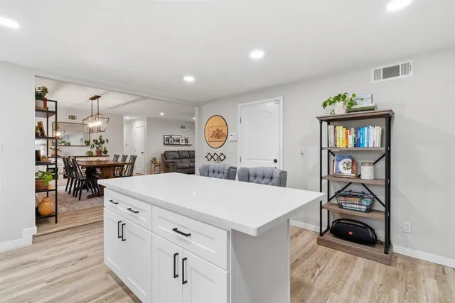 a kitchen with a table chairs refrigerator and cabinets