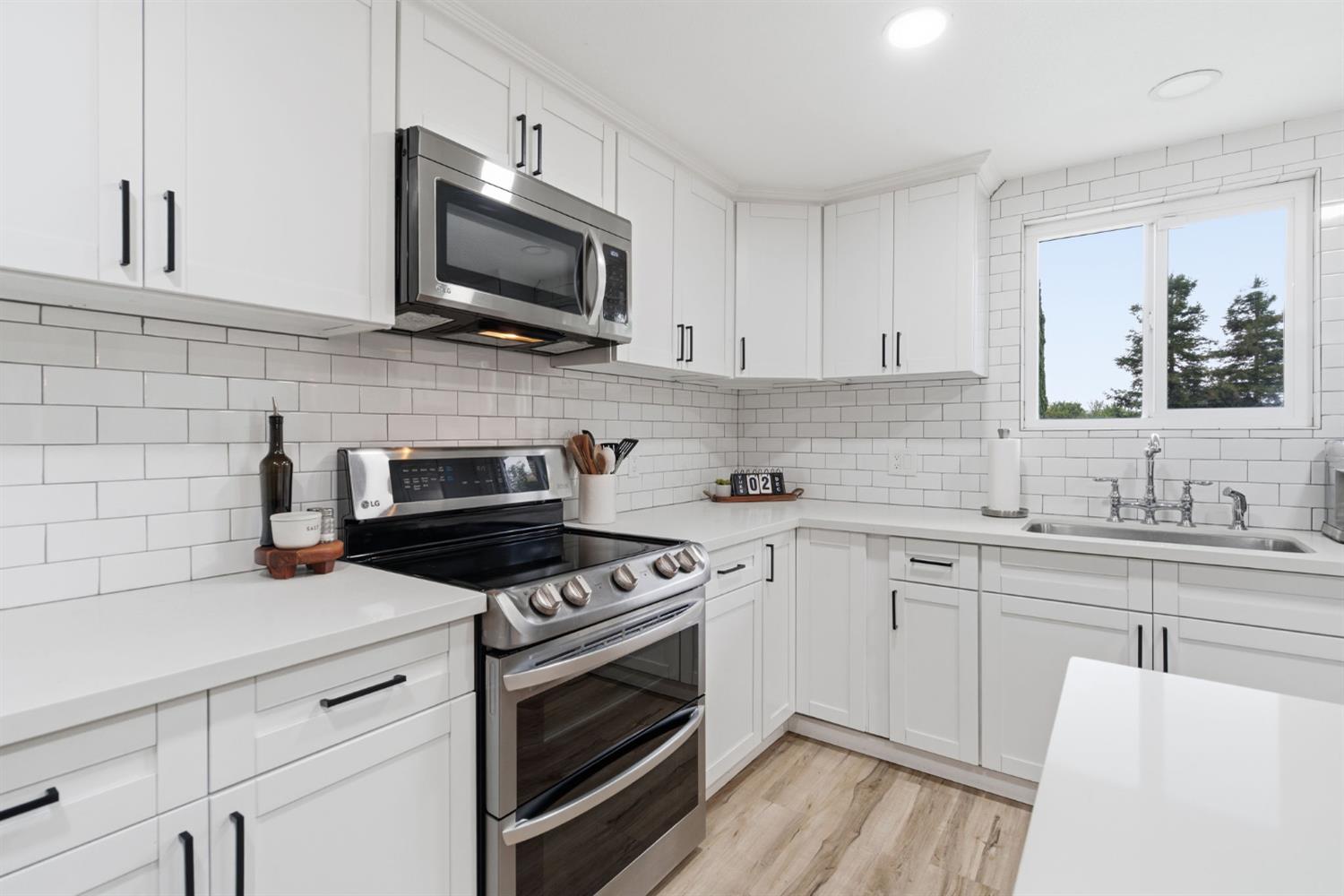 15581 French Camp Road Ripon, CA 95366 - Photo 22 of 54 a kitchen with cabinets stainless steel appliances a sink and wooden floor
