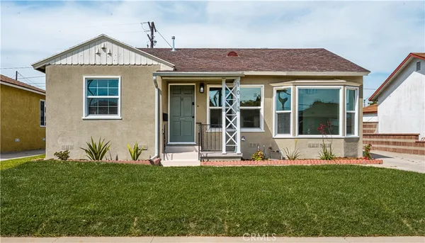 a front view of a house with a yard and trees