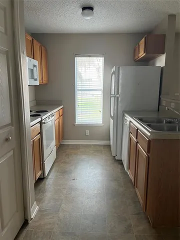 a kitchen with a sink a stove and a refrigerator