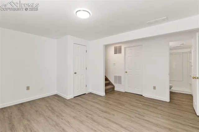 a view of an empty room with wooden floor