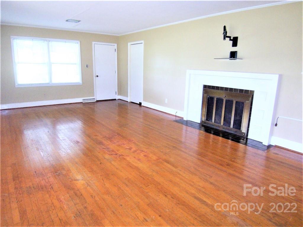 4529 Fallston Road Lawndale, NC 28090 - Photo 7 of 38 an empty room with wooden floor fireplace and windows