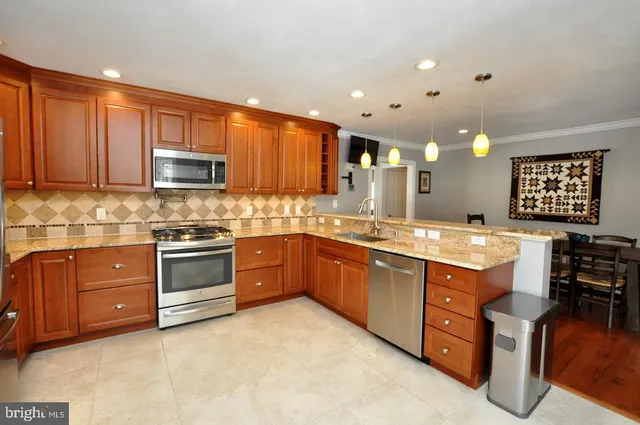 a kitchen with stainless steel appliances granite countertop a stove sink and cabinets