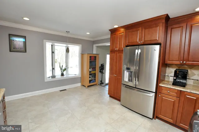 a kitchen with stainless steel appliances a refrigerator and wooden cabinets