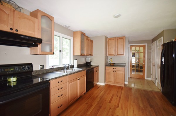 175 Tinkham Road Springfield, MA 01129 - Photo 3 of 30 a kitchen with a refrigerator a stove a sink wooden floor and cabinets