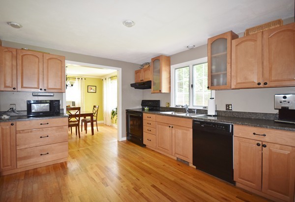 175 Tinkham Road Springfield, MA 01129 - Photo 5 of 30 a kitchen with granite countertop a stove top oven a sink a dining table and chairs with wooden floor