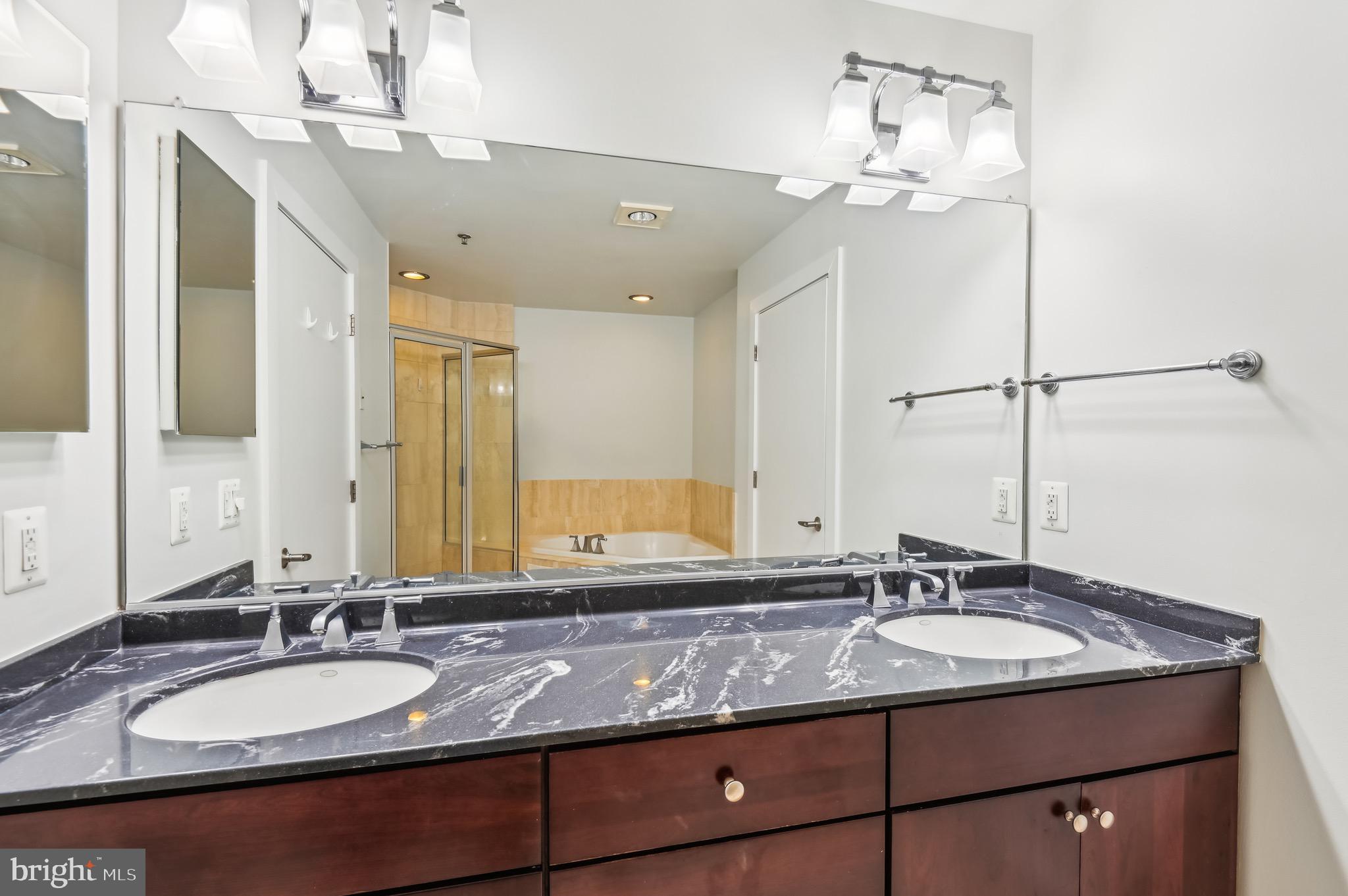 1400 Lancaster Street, Unit 502 Baltimore, MD 21231 - Photo 31 of 48 a bathroom with a granite countertop sink and a mirror