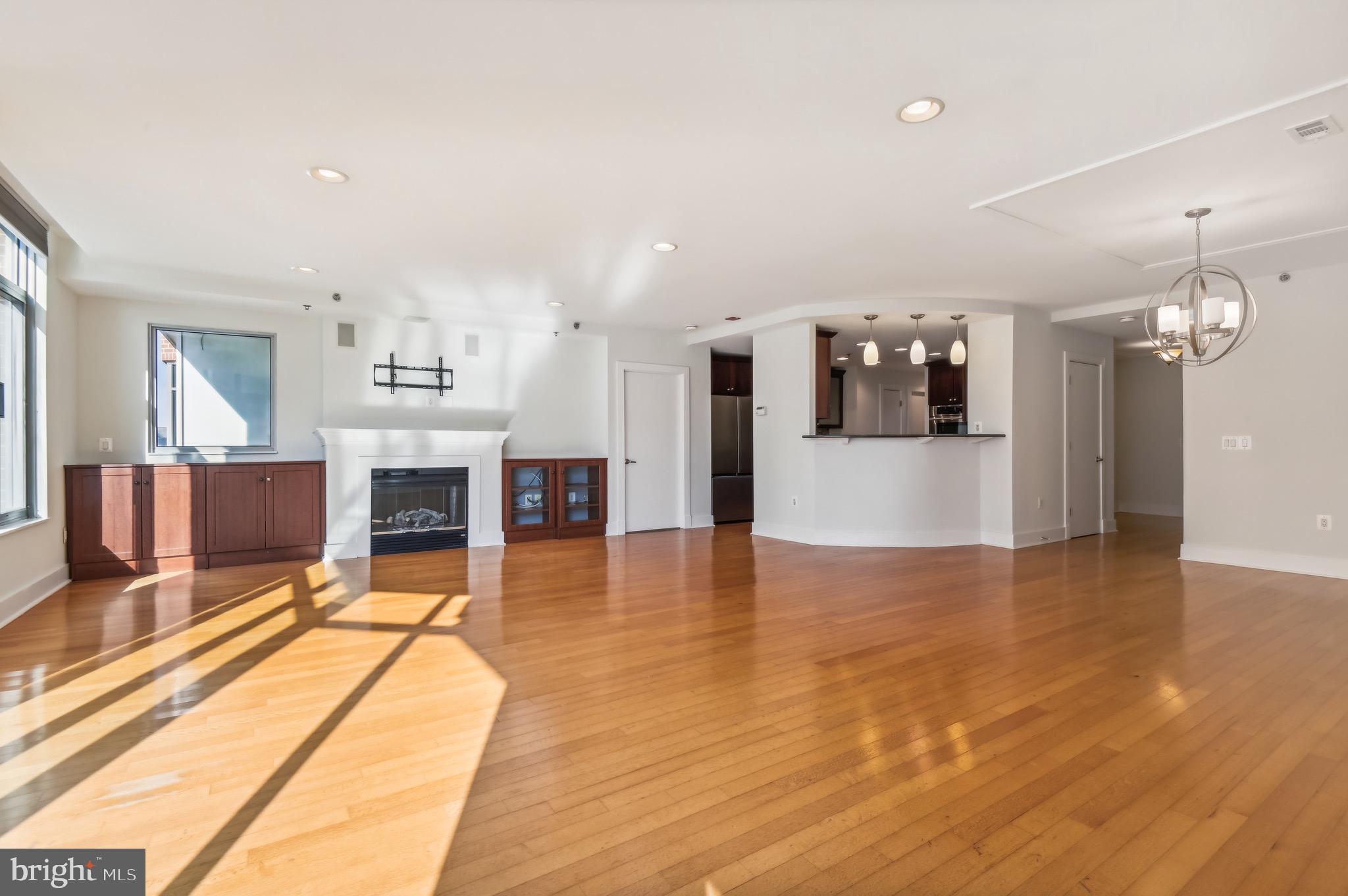 1400 Lancaster Street, Unit 502 Baltimore, MD 21231 - Photo 5 of 48 a view of a living room and kitchen with furniture and wooden floor