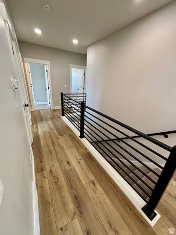 1184 West 3250 North Ogden, UT 84414 - Photo 39 of 69 Hallway featuring lap wood style flooring, recessed lighting, and a contemporary black metal baluster railing