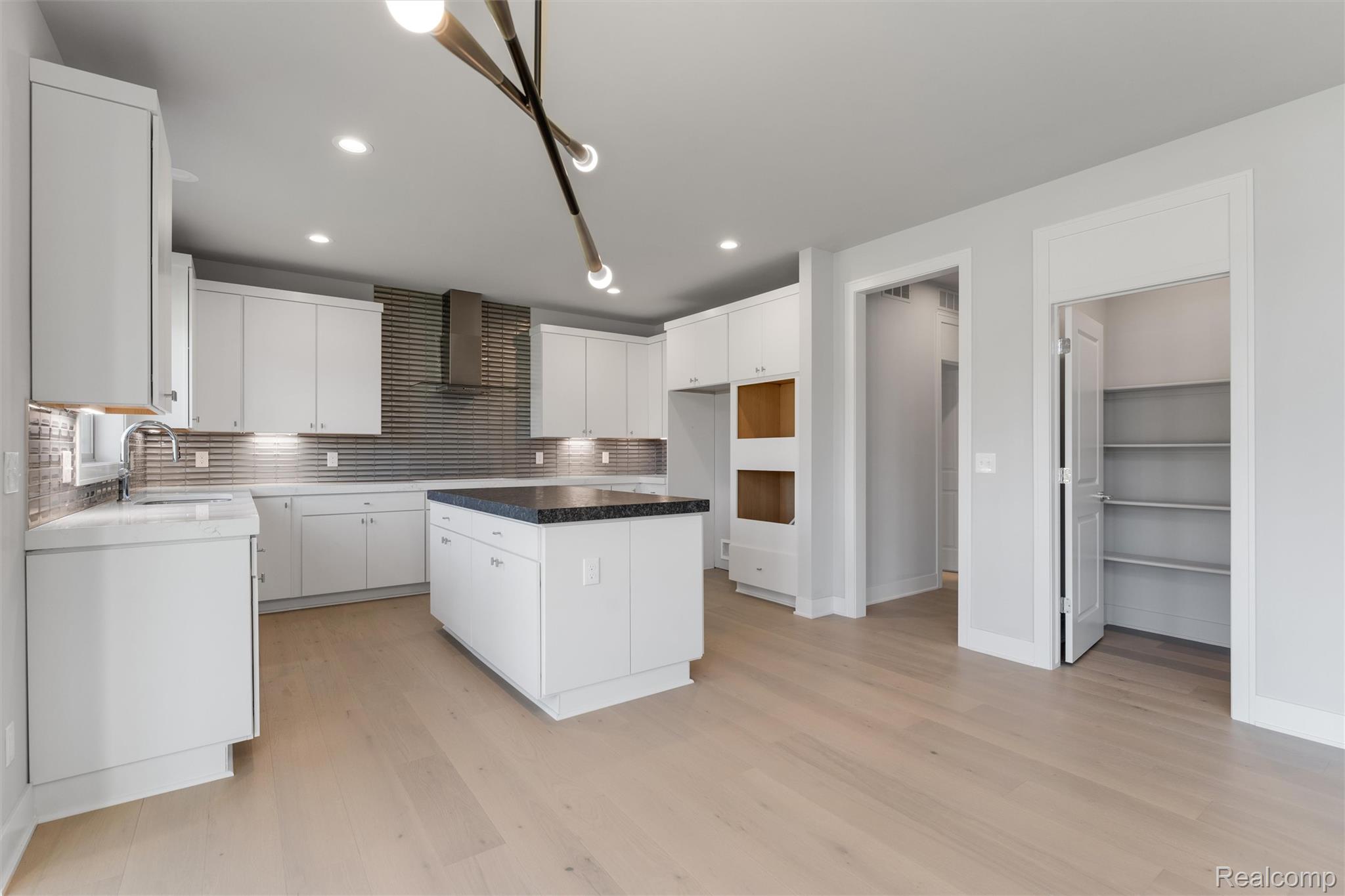 3989 Capstan Court Troy, MI 48083 - Photo 7 of 19 Kitchen with decorative backsplash, a center island, white cabinetry, light wood-type flooring, and recessed lighting