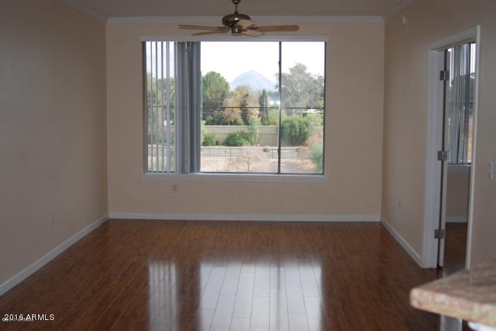 1701 East Colter Street, Unit 333 Phoenix, AZ 85016 - Photo 5 of 36 an empty room with wooden floor and windows