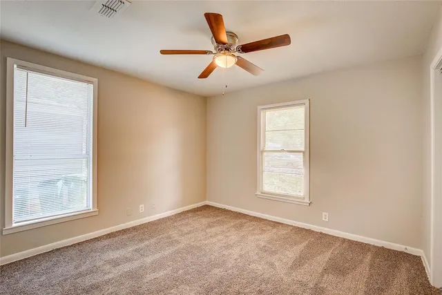 an empty room with closet and a chandelier fan