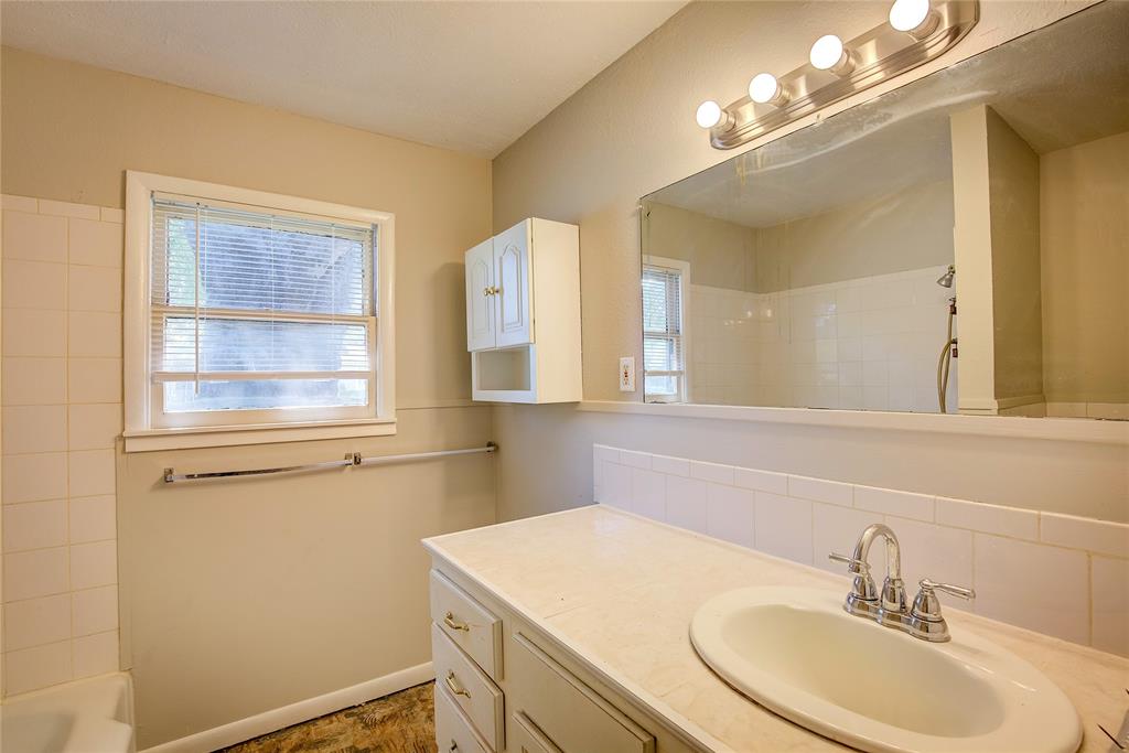 620 Harrison Lane Hurst, TX 76053 - Photo 19 of 32 a bathroom with a sink vanity and a mirror