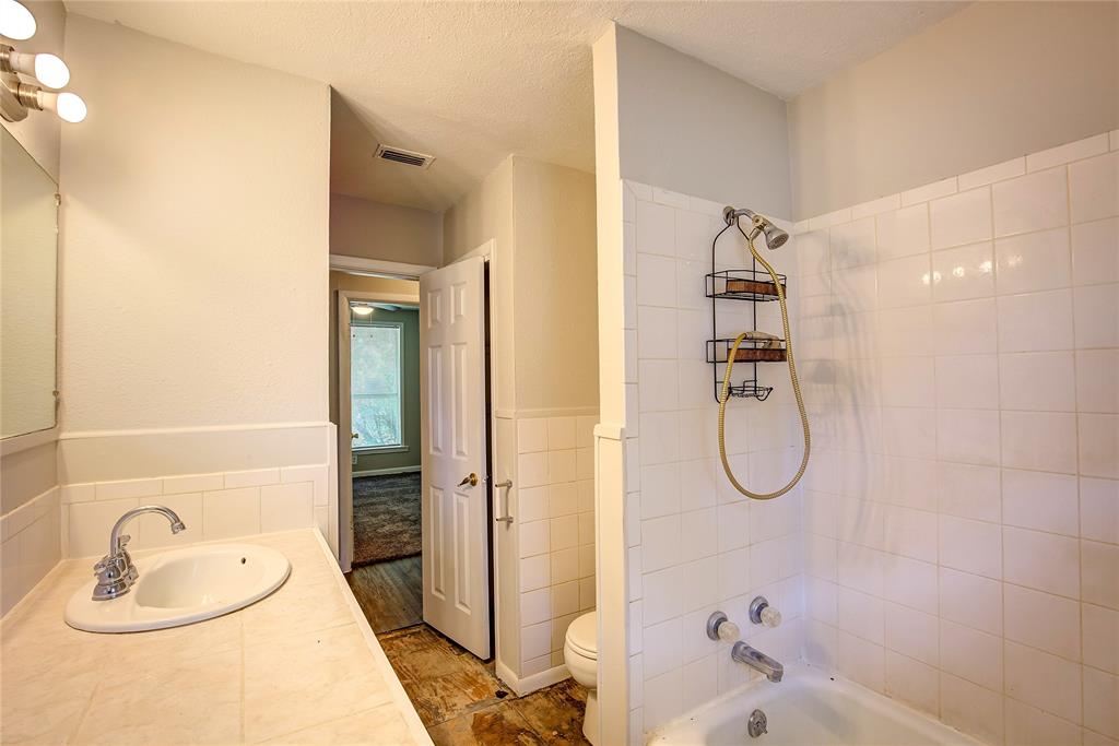 620 Harrison Lane Hurst, TX 76053 - Photo 20 of 32 a bathroom with a granite countertop sink a toilet and shower