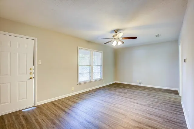 wooden floor in an empty room with a window