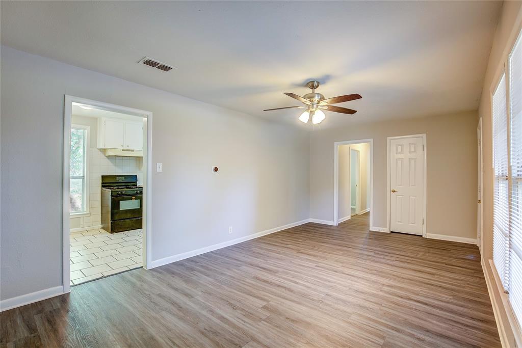 620 Harrison Lane Hurst, TX 76053 - Photo 9 of 32 an empty room with wooden floor and a ceiling fan