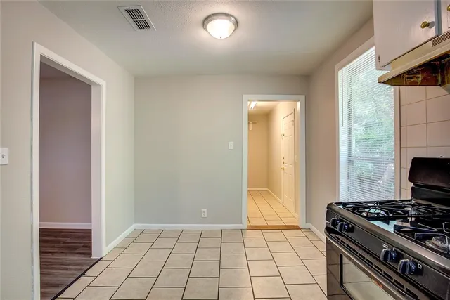 a kitchen with granite countertop a stove top oven and cabinets
