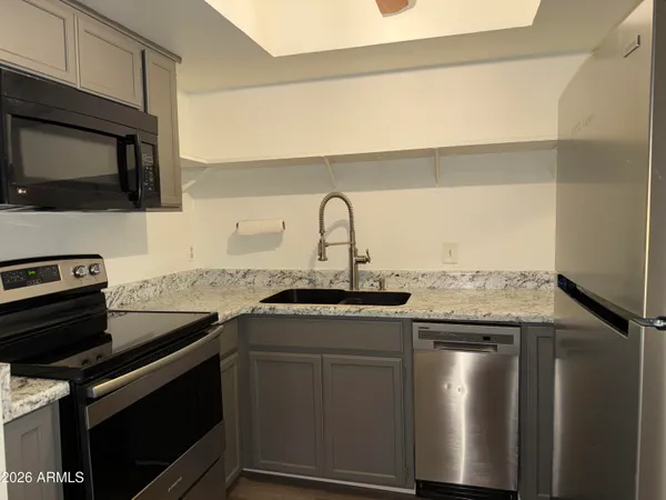 a kitchen with stainless steel appliances kitchen island granite countertop a stove and a sink