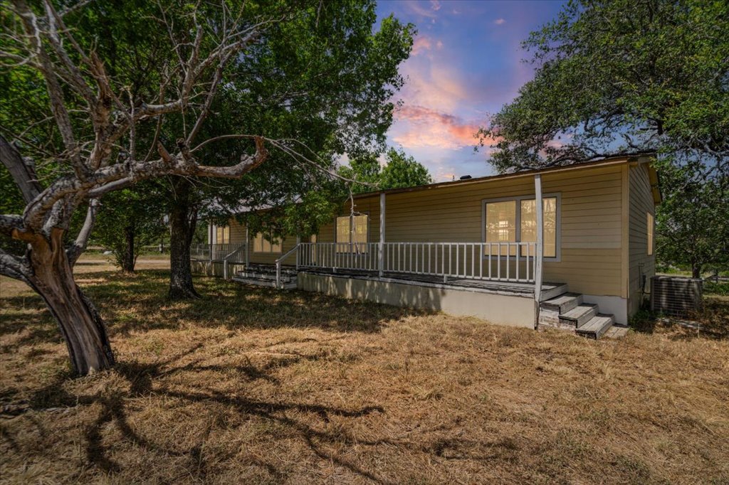 13501 Nutty Brown Road, Unit B Austin, TX 78737 - Photo 27 of 29 Mature trees frame this charming, ranch-style home with an inviting front porch and a vast natural landscape.