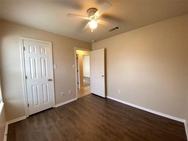 an empty room with a window and a fan
