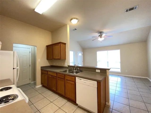 a kitchen with kitchen island granite countertop a sink and a stove